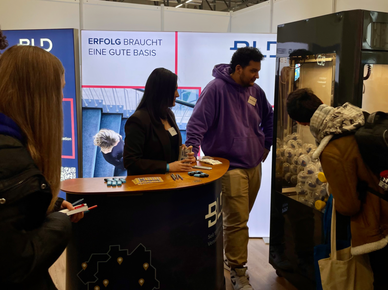 Auf dem Bild sieht man den BLD Stand und vier Personen drauf.