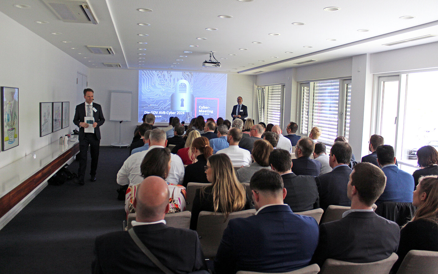 Das Bild entstand auf dem zweiten Cyber-Meeting. Auf dem Bild sieht man die Teilnehmer, welche auf den Stühlen sitzen und dem Meeting zu hören.