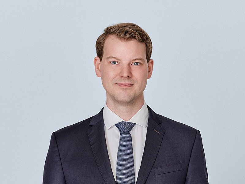 Es ist ein Portraitfoto von Florian Henn